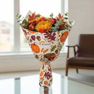 Emballage en papier coloré sur le thème de l'automne avec motif de citrouille et de feuille, adapté pour l'emballage de cadeaux ou de vente au détail