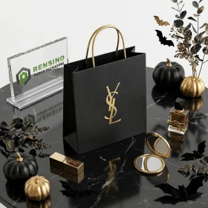 Sac en papier noir avec poignées dorées et logo Yves Saint Laurent, adapté pour l'emballage cadeau, les cosmétiques ou les bijoux, design personnalisé disponible