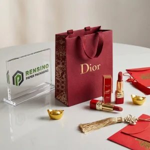 Sacchetto di carta rossa con logo in foglia d'oro e manici, adatto per imballaggio regalo o cosmetico, stampa del logo personalizzata disponibile