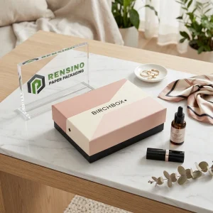 Boîte en papier rose et noire avec texte imprimé “BIRCHBOX” et motif géométrique, adaptée pour l'emballage de cadeaux, cosmétiques ou de détail, design personnalisé disponible