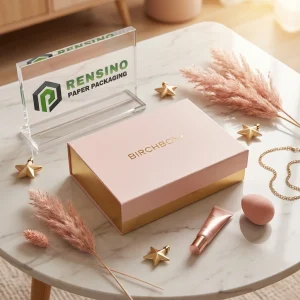 Boîte cadeau en papier rose et doré avec texte imprimé “BIRCHBOX” et design élégant, adaptée pour l'emballage de cadeaux, cosmétiques ou de vente au détail, design personnalisé disponible