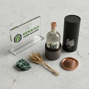 Emballage en tube en papier noir avec texte stylisé imprimé et couvercle en cuivre, adapté pour l'emballage de boissons, design personnalisé disponible