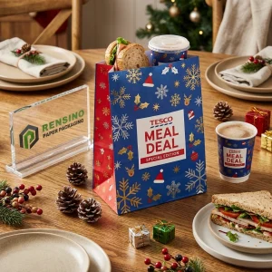 Sacs en papier alimentaires jetables bleus et rouges avec motif de flocon de neige et texte imprimé “TESCO MEAL DEAL”, design personnalisé disponible