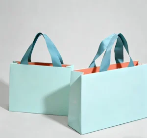 Two-Tone Mint Green and Orange Cardboard Tote Bags with Hand-Length Handles and Custom Logo